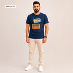 A man modeling a navy blue graphic t-shirt with a retro radio and Bengali text design, paired with beige trousers and white sneakers, against a solid light beige background. A 'REGULAR FIT' label is visible in the top-left corner.