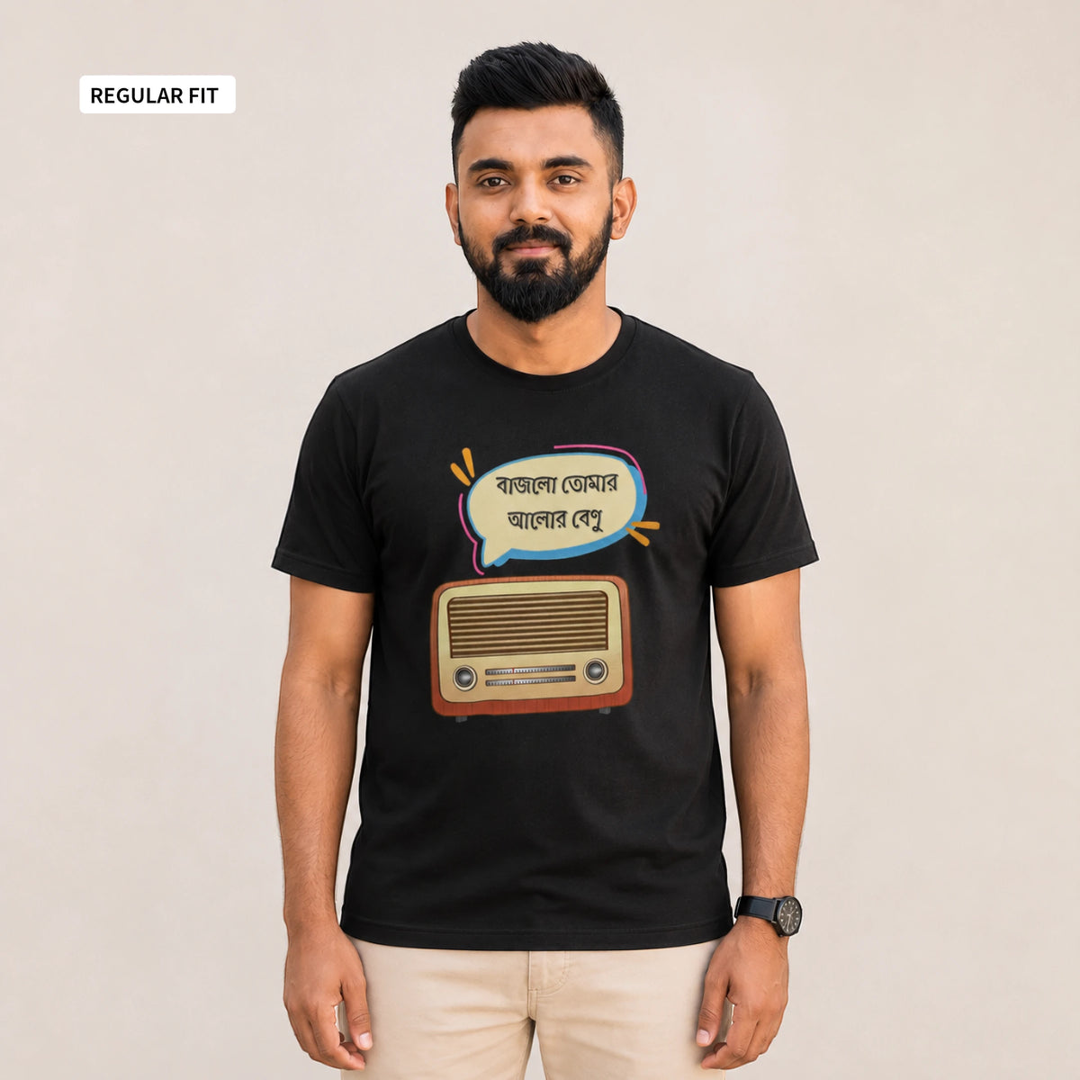A man wearing a black short-sleeve t-shirt with a retro radio and Bengali text graphic, paired with beige pants, standing against a plain beige background.