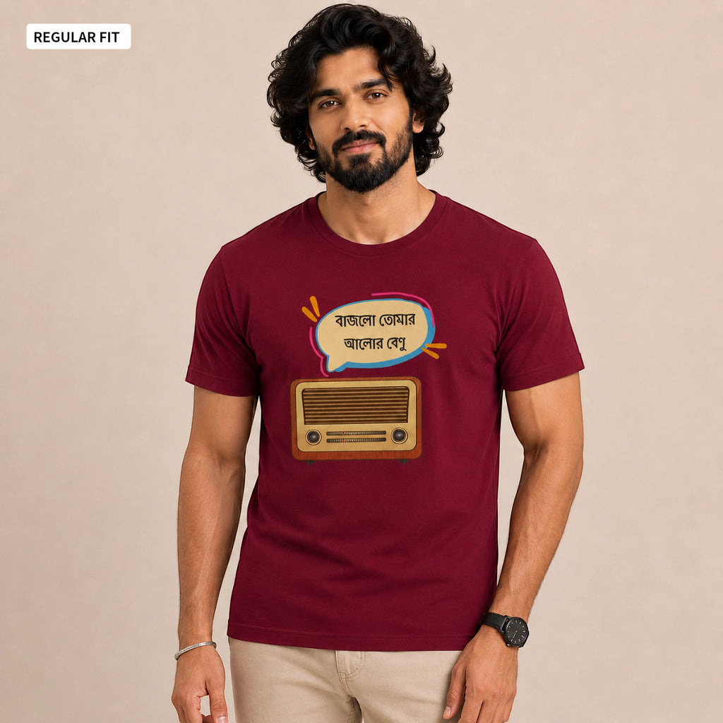 A man wearing a maroon short-sleeve t-shirt with a graphic of a retro radio and Bengali text inside a speech bubble. The image has a beige background and a 'REGULAR FIT' label in the top-left corner.