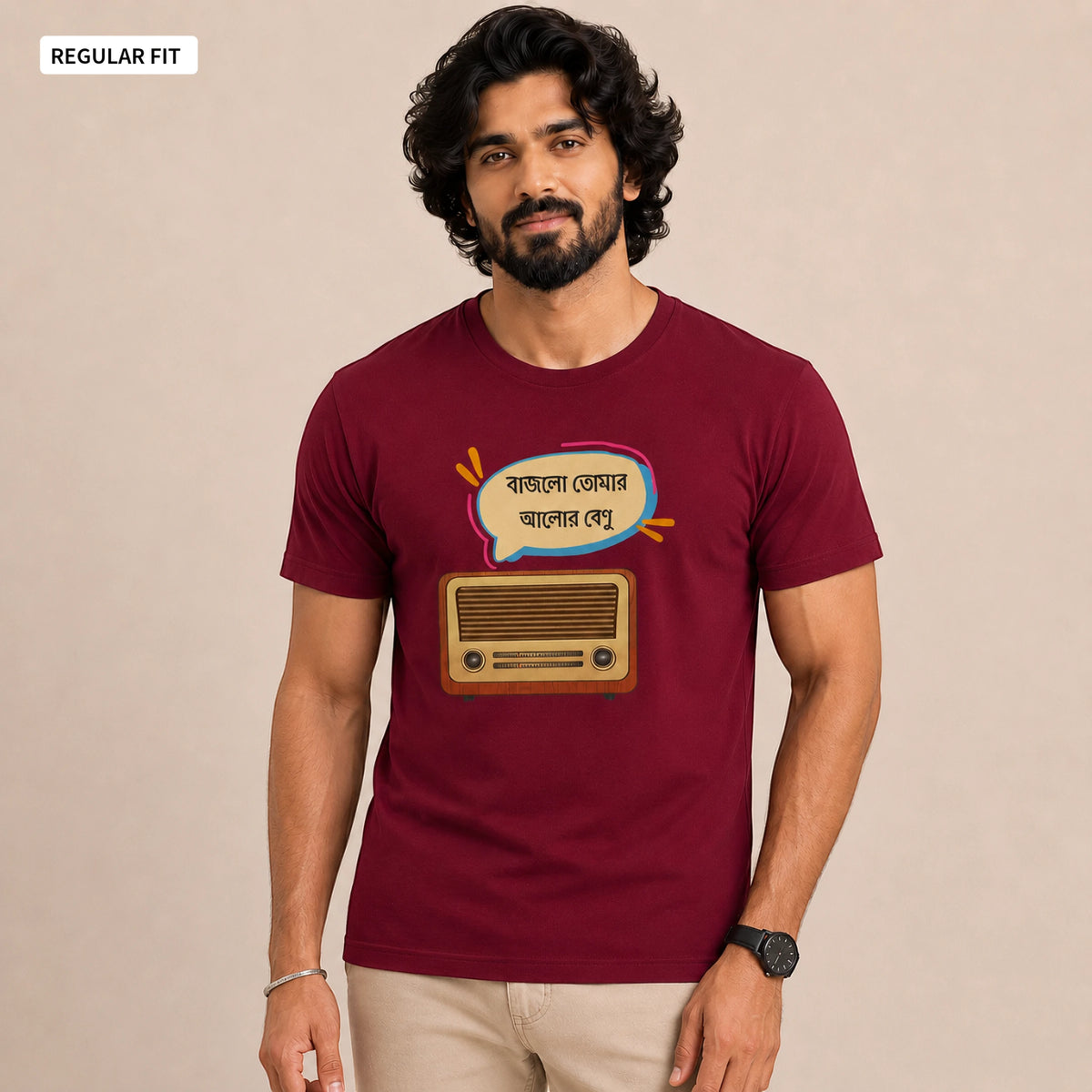A man wearing a maroon short-sleeve t-shirt with a graphic of a retro radio and Bengali text inside a speech bubble. The image has a beige background and a 'REGULAR FIT' label in the top-left corner.