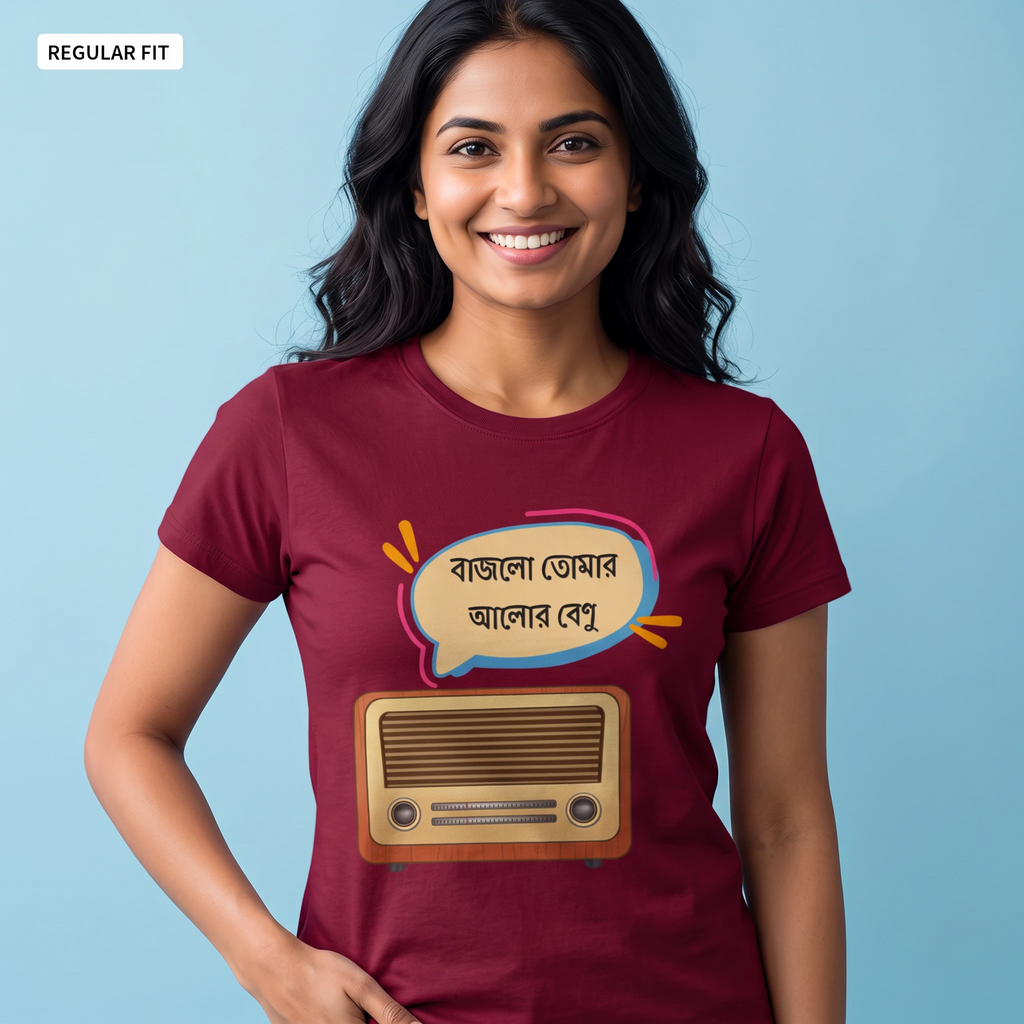 A woman wearing a maroon short-sleeve t-shirt with a graphic print of a retro radio and a speech bubble with Bengali text, set against a light blue background.
