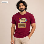 A man wearing a maroon short-sleeve t-shirt with a graphic of a retro radio and Bengali text inside a speech bubble, paired with beige pants, against a plain beige background.