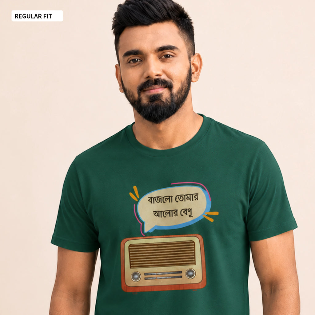 A man wearing a dark green graphic t-shirt with a cartoon radio and Bengali text bubble on the front, set against a plain beige background.