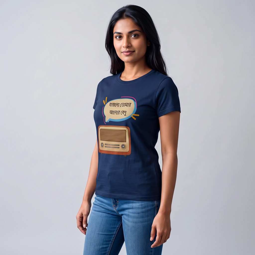 A woman modeling a navy blue short-sleeve t-shirt with a graphic print of a vintage radio and Bengali text inside a speech bubble, paired with blue jeans against a light gray studio background.