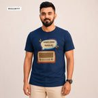 A man wearing a navy blue graphic t-shirt with a retro radio and speech bubble design in Bengali, paired with beige pants, against a plain beige background.