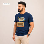 A man wearing a navy blue t-shirt with a graphic of a retro radio and a speech bubble in Bengali, paired with beige pants, standing against a plain beige background.