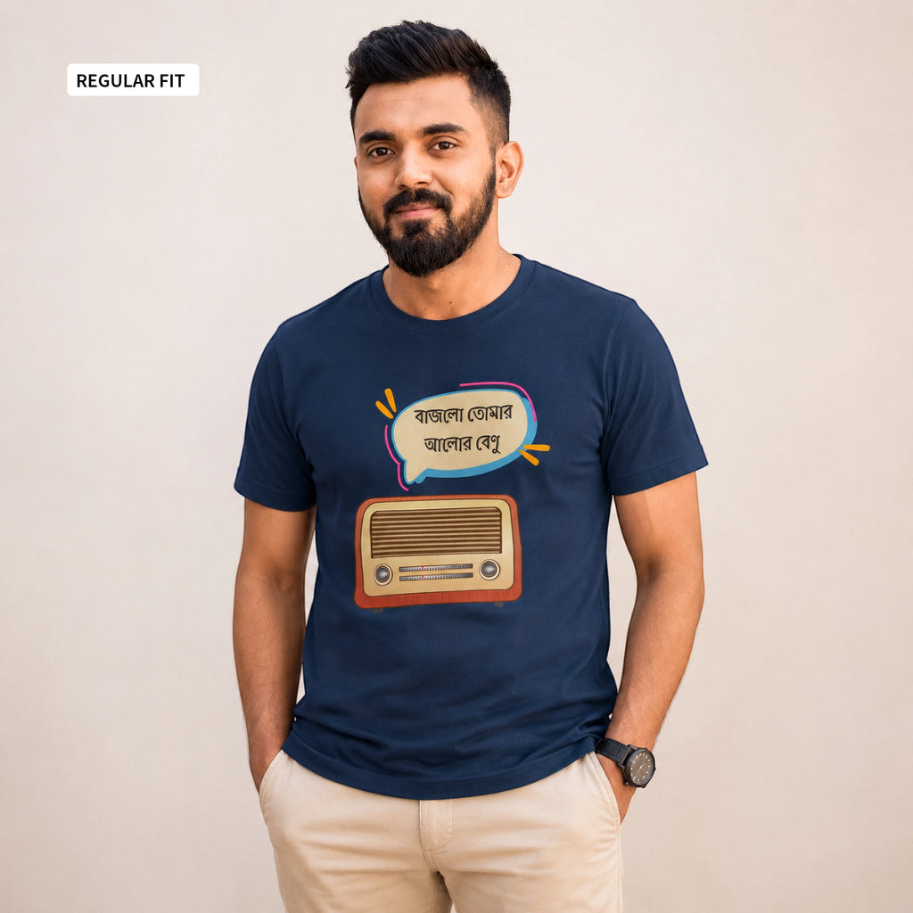 A man wearing a navy blue t-shirt with a graphic of a retro radio and a speech bubble in Bengali, paired with beige pants, standing against a plain beige background.