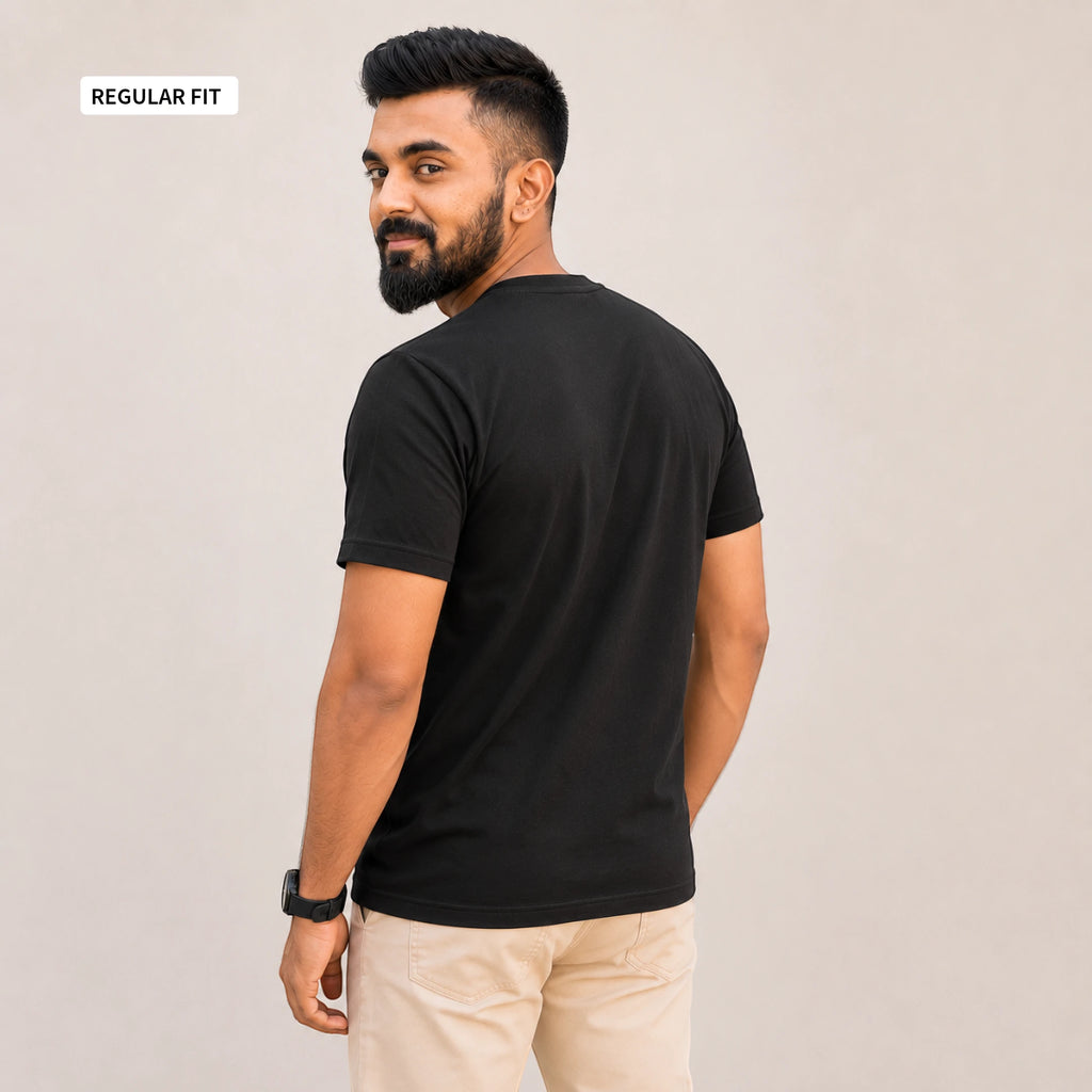 A man wearing a black short-sleeve t-shirt and beige pants, shown from the back and side against a plain light gray background. A small label in the top-left corner reads 'REGULAR FIT'.