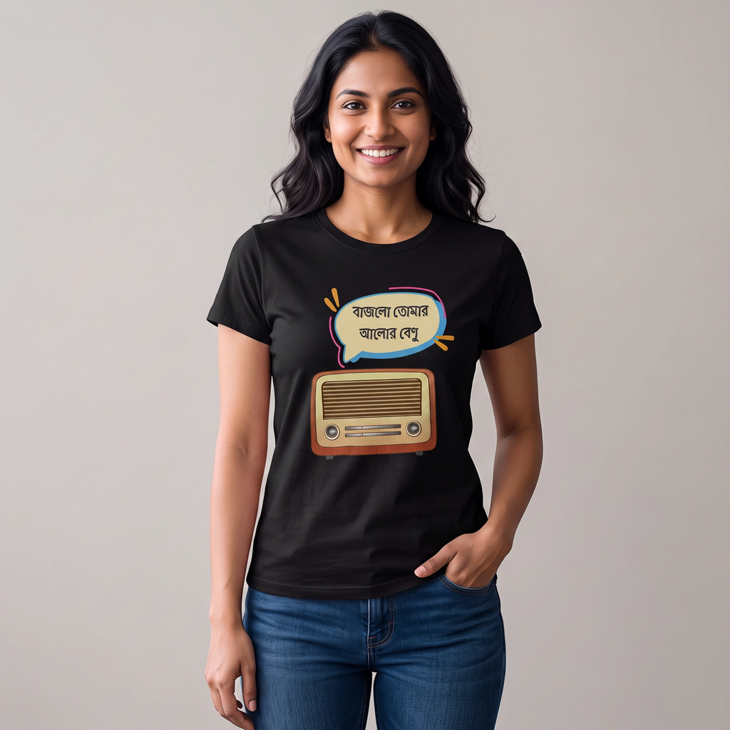 A woman wearing a black graphic t-shirt with a cartoon radio and Bengali text print, paired with blue jeans, standing against a plain light gray background.