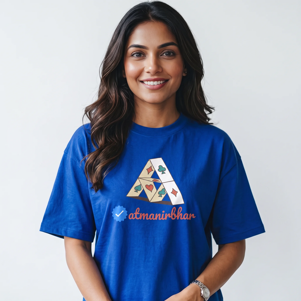 A smiling woman with long dark hair wearing a royal blue t-shirt with a graphic of a geometric triangle and the text 'atmanirbhar' on the front, set against a plain light gray background.