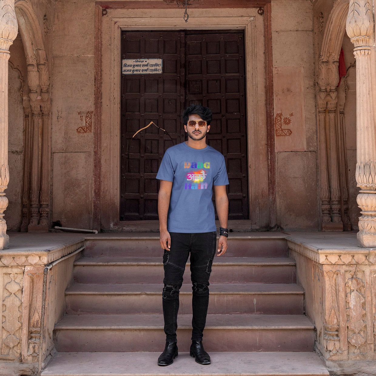 Man standing on steps in front of an ornate building entrance